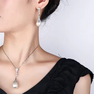 Elegant pearl pendant necklace and drop earrings jewelry set on model detail shot