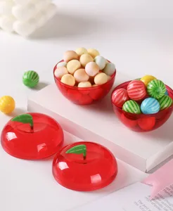 Detail shot of a transparent red apple-shaped plastic box with green leaf stem, ideal for gifts.