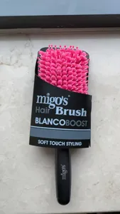 Detailed view of the quick-dry hair brush featuring soft pink bristles and black handle.
