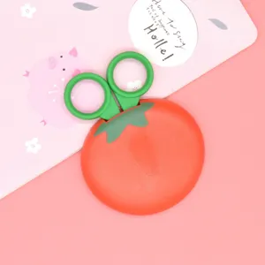 Close-up detail of the cute tomato shaped safety scissors with green protective case.