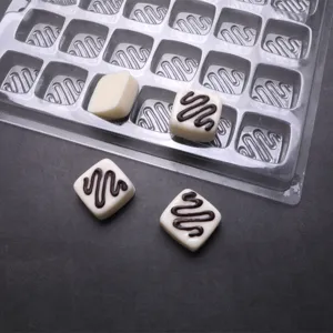 Dettaglio ravvicinato dello stampo per cioccolatini in plastica PET con cavità quadrate.