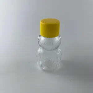 Dettaglio della bottiglia orsetto in plastica trasparente con tappo giallo per succhi.