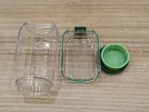 Klarsicht Kunststoff Salatbehälter Detailansicht mit Messmarkierungen und grünem Einsatzbecher.