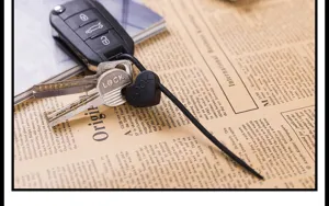 Close-up detail of the black silicone lock cable tie and metal keys on a retro newspaper background.