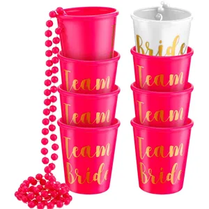 Detail view of bachelorette party plastic cups with team bride text and pink bead necklaces.