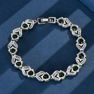 Vista ravvicinata dettagliata del bracciale vintage argentato con pietre verdi e strass.