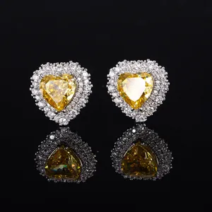 Detailaufnahme von funkelnden herzförmigen gelben Diamant-Ohrringen mit eleganter Silberfassung.