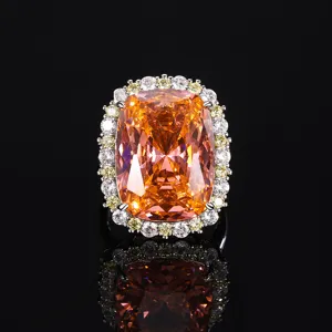 Detail van een luxe kussengeslepen oranje edelsteenring met briljanten en diamantkrans.