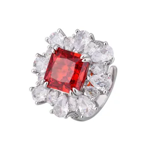 Elegante anello con pietra rossa taglio principessa circondato da cristalli a goccia.
