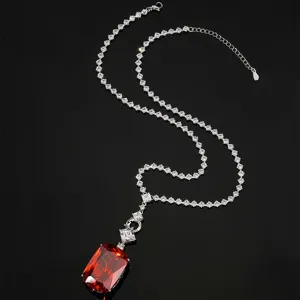 Gros plan d'un collier pendentif de luxe grand diamant carré rouge avec chaîne étincelante.