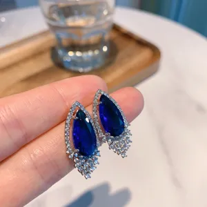 Close-up detail of stunning pear-shaped blue gemstone earrings sparkling with micro cubic zirconia.