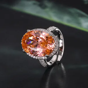 Splendido primo piano di un grande anello con pietra preziosa ovale arancione e dettagli pavé.