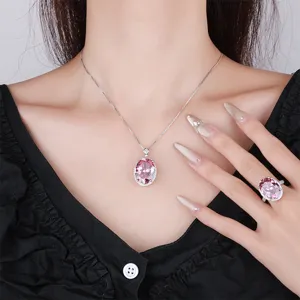 Elegante set di gioielli con collana e anello con pietra rosa ovale e alone brillante.