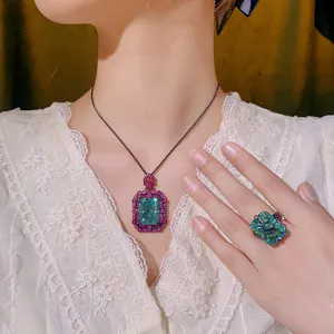 Luxury radiant cut green gemstone necklace and ring set with black and pink details.