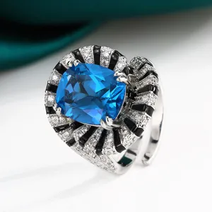 Vue détaillée de la bague créative avec pierre précieuse bleue et émail noir étincelant.