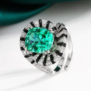Élégante bague avec pierre verte taillée en coussin et design rayonnant noir et blanc.