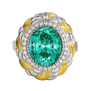 Detailed close-up of vintage dual-tone twisted cable ring with oval green gemstone and crystal halo.
