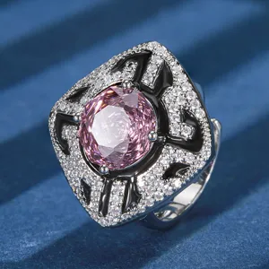 Primer plano detallado de anillo de lujo con gema rosa, pavé de cristales blancos y esmalte negro.