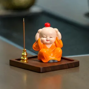 Vista detallada de un adorable quemador de incienso de monje con bandeja de madera para mesa.