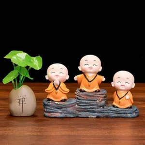 Vue détaillée de figurines zen de petits moines mignons en résine avec mini pot de plante.