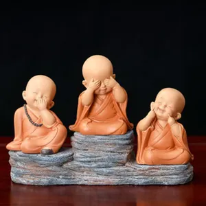 Vue détaillée de figurine de petit moine en résine, idéale pour déco de bureau relaxante.