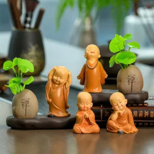 Vue détaillée de pots de plantes de moine en résine mignons, décoration de bureau zen.