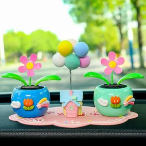 Lindo adorno solar oscilante para el tablero de coche con una casita y globos decorativos.