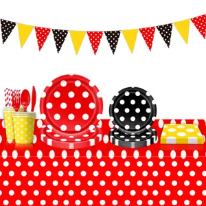 Conjunto de vajilla para fiesta de cumpleanos con platos de papel coloridos y mantel de lunares.