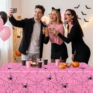 Halloween party scene showing pink spiderweb disposable PE tablecloth detail and decorations.
