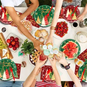 Kerstfeest tafelscène met feestelijke wegwerp borden, bekers en tafeldecoratie.