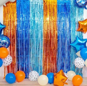 Blue and orange fringe curtain party backdrop with paw print balloons for birthday celebration details.