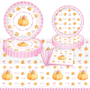 Vista detallada de platos de papel y servilletas con calabaza y lazo rosa para fiesta