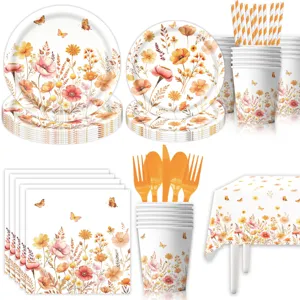 Dettaglio set stoviglie per feste con fiori autunnali piatti bicchieri tovaglioli e tovaglia.