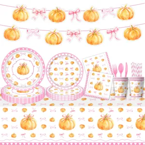 Detalle de artículos de fiesta de calabaza rosa con platos, tazas y servilletas.