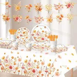 Set di stoviglie per feste con fiori autunnali, piatti, bicchieri, tovaglioli e tovaglia.