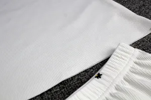 Close-up detail of white ribbed cotton pajama shorts and fabric texture, soft loungewear.