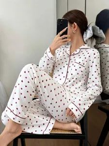 Detail shot of women's long sleeve pajama set with cute red heart print and lapel collar.