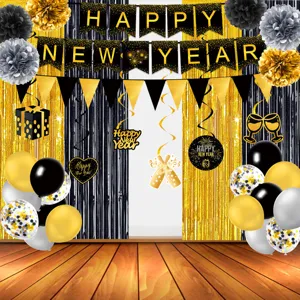 Black and gold New Year party decoration details showing banner and tinsel backdrop setup.