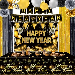Black and gold New Year party decoration set detail showing banners, backdrop and tablecloth.