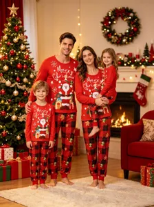 Christmas family matching pajamas detail shot showing festive red top and plaid trousers.