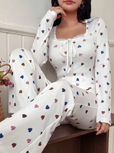 Detailaufnahme des bequemen Damen Langarm Hausanzugs mit bunten Herzen und Spitzen.