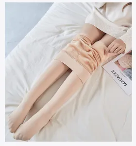 Gros plan détail de collants thermiques chair doublés de polaire douce posés sur le lit.