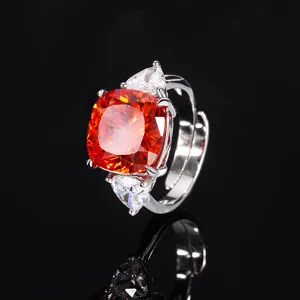 Silver-tone ring with vibrant orange cushion main stone and pear side stones.