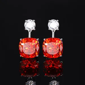 Close-up of elegant drop earrings featuring sparkling white and vibrant orange cushion-cut stones.
