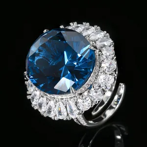 Primer plano detallado de un lujoso anillo de cóctel de gran gema azul con halo de circonitas.