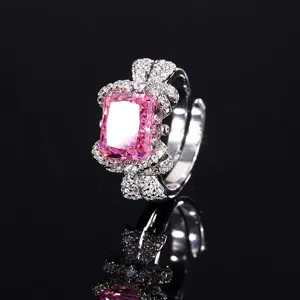 Detailopname van prachtige roze edelsteenring met strikmotief en schitterende steentjes.