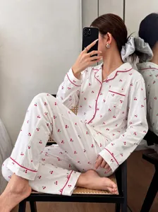 Detail shot of women long sleeve cherry print pajama set, soft cotton fabric, red piping.