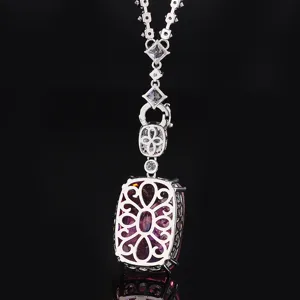 Luxury pink gemstone pendant necklace detail view with ornate silver filigree metal setting.