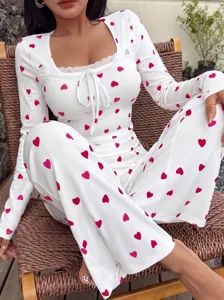 Nahaufnahme Damen weißer Rippstrick Hausanzug mit rosa Herzen, Spitze und Bindebändern.