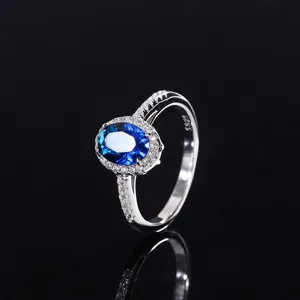 Vue détaillée d'une bague élégante en argent 925 avec une pierre bleue ovale étincelante.